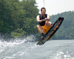Wakeboarder jumps the wake.